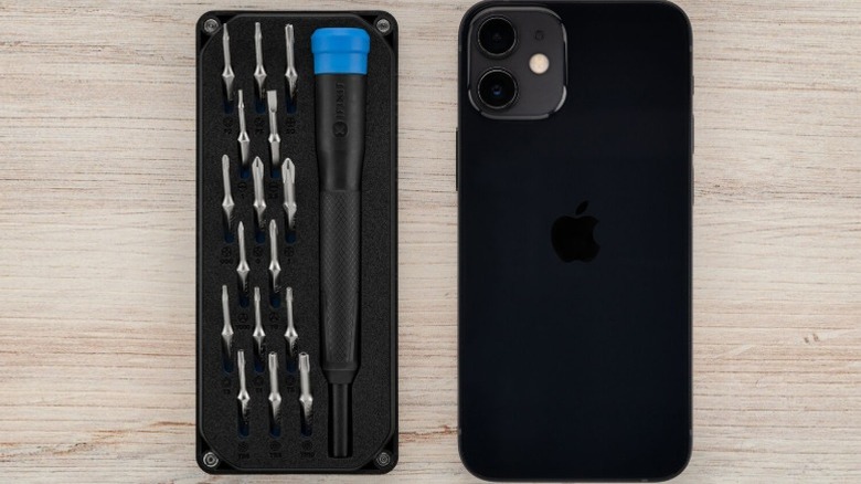 A top-down shot of the iFixit Minnow precision screwdriver kit next to an iPhone