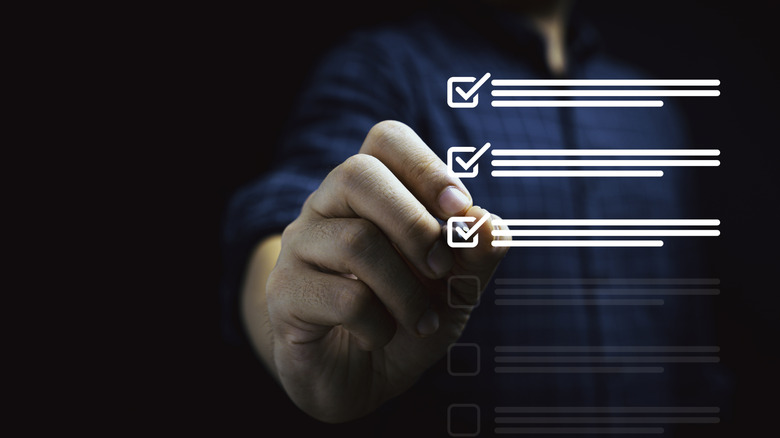 A man using a pen to tick boxes in a checklist