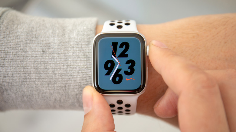 Man's hand using Apple Watch using Nike Face
