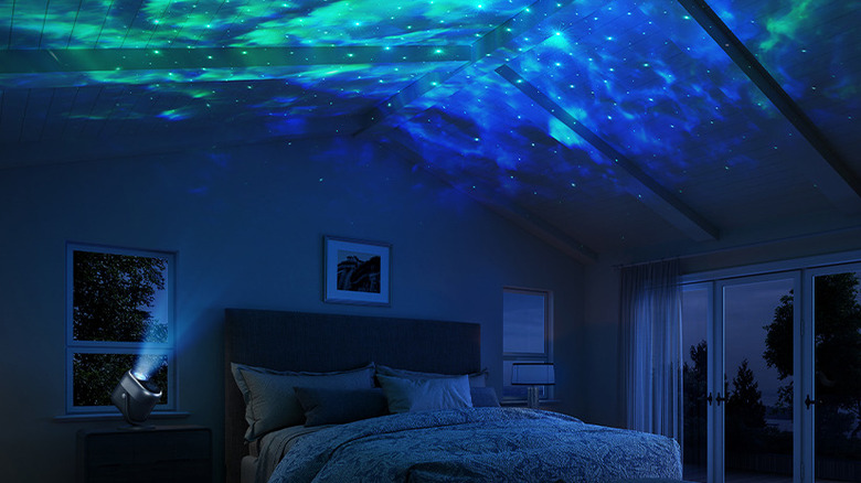The Govee Star Light Projector projecting a nebula pattern on the ceiling of a bedroom.