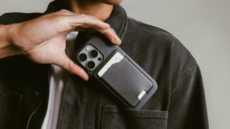 A person keeping an iPhone with Nomad MagSafe Wallet in his pocket
