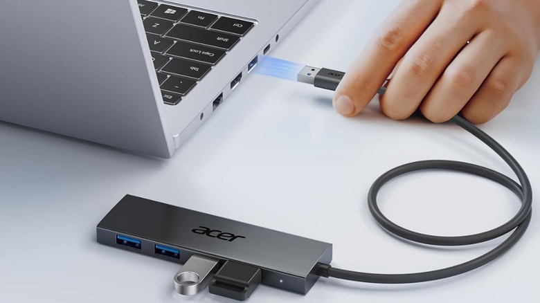 Man connecting  an Acer USB hub to a laptop