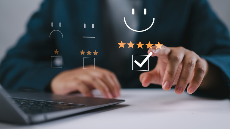 Finger pointing at a holographic image of five star rating