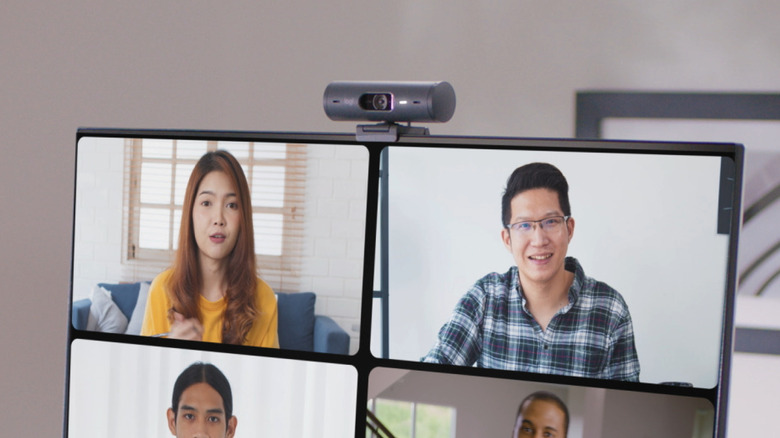 The Logitech Brio 500 clipped onto the top of a monitor during a video call