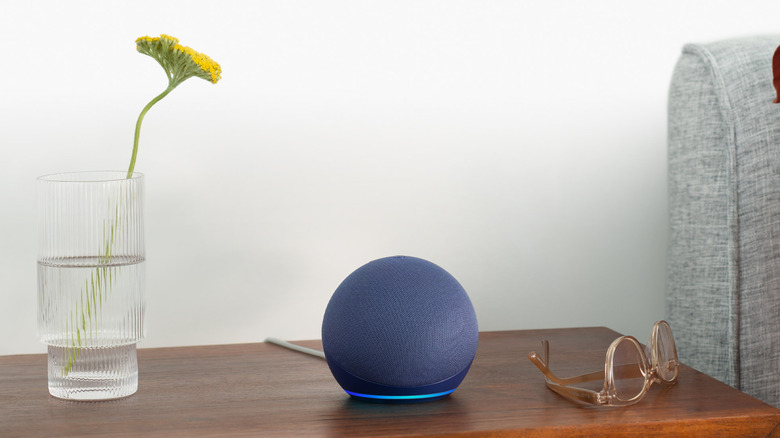 The Amazon Echo Dot (5th Gen) smart speaker on a wooden table.