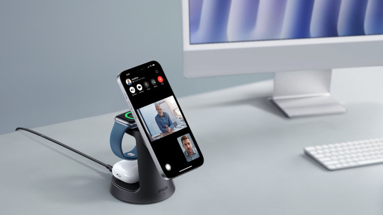 An iPhone, AirPods, and Apple Watch charging on the Anker A25M4 MagGo wireless charging station.