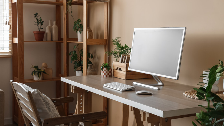A home office with a computer, keyboard, and mouse on a wooden desk.