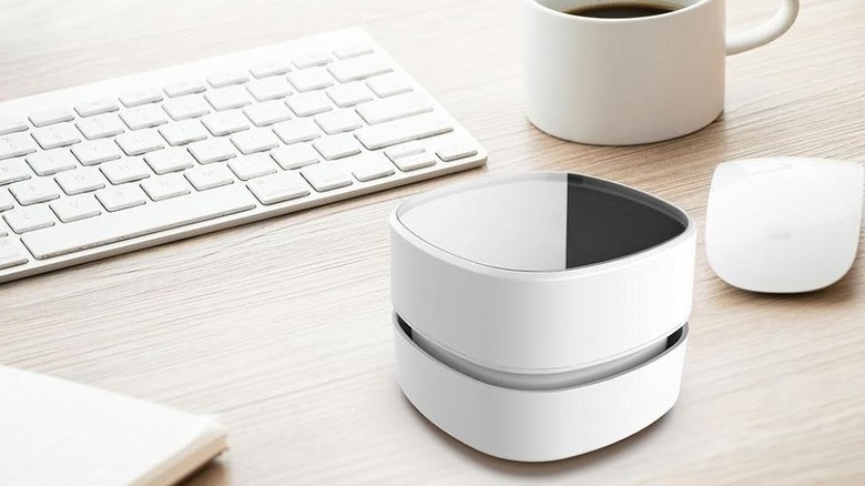 The Odistar HL-306 desktop vacuum cleaner on a desk with a keyboard, mouse, and mug.