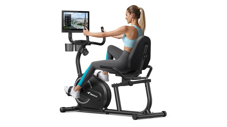 A woman using the Merach S08 recumbent exercise bike.