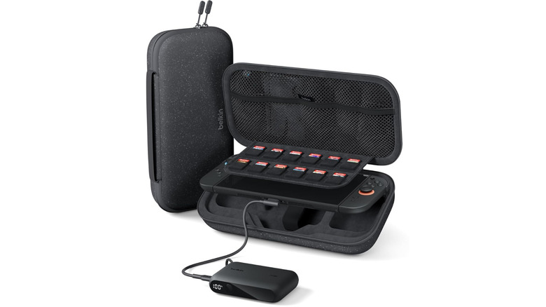 A black hard-shell carrying case for a hand-held gaming console, shown open with game cartridges, a portable battery pack, with storage compartments visible inside, all against a white background.