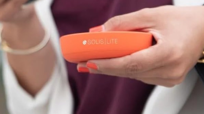 The Solis Lite held by a woman while she connects her smartphone