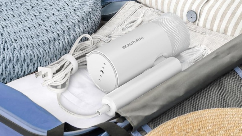 The Beautural Portable Clothes Steamer, folded and placed in a suitcase