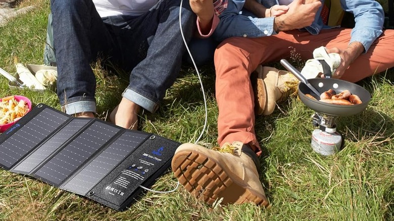 The solar charged placed on the ground next to a group of people