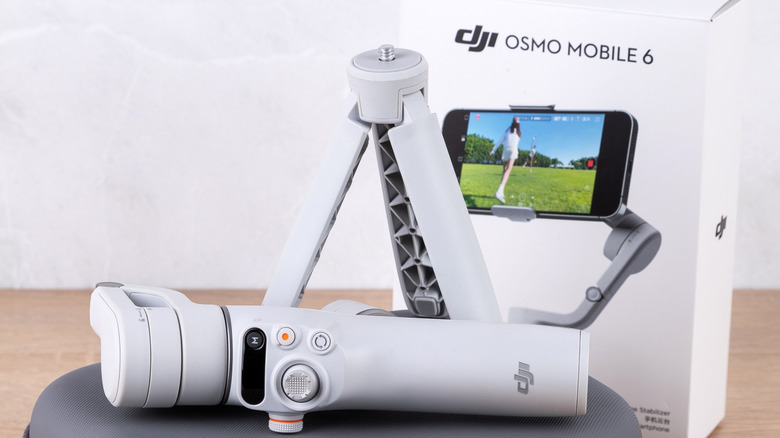 The DJI Osmo Mobile 6 gimbal out of its packaging on a wooden surface
