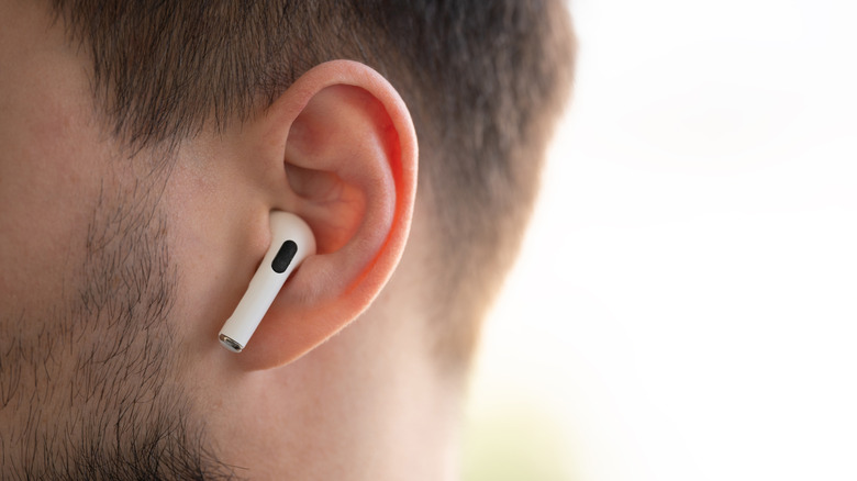 Apple airpods inside a person's ears.