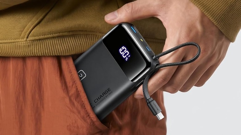 A person placing the INIU P51L power bank in their pocket.