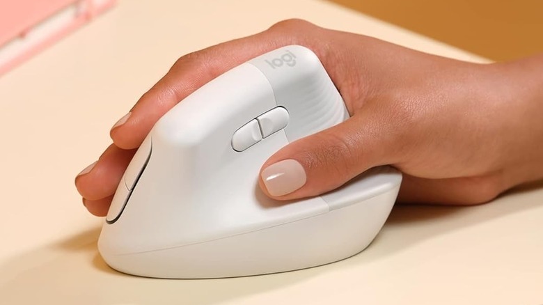 A person holding the Logitech Lift Vertical Ergonomic Mouse in their hand.