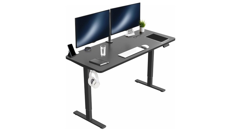 The Vivo Electric Standing Desk with monitors, keyboard, mouse, and other items.