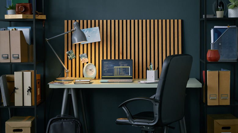 A table in a home office with a laptop and other work-related items.