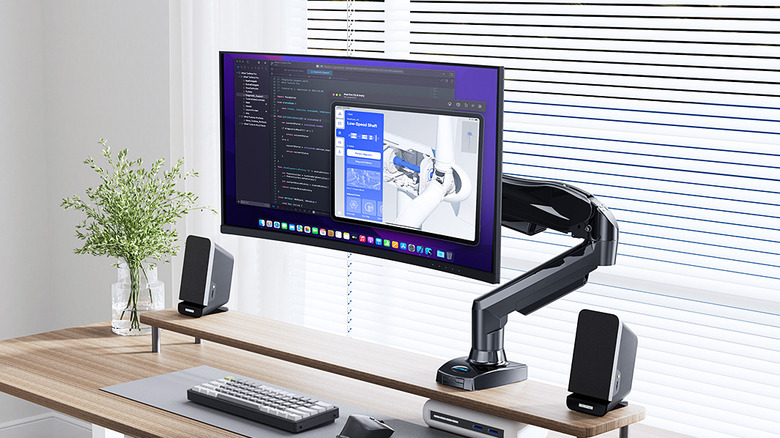 The Huanuo HNSS6 FlowLift monitor mount installed on a computer desk.