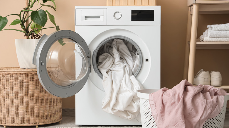 A clothes dryer with laundry items spilling out the front.