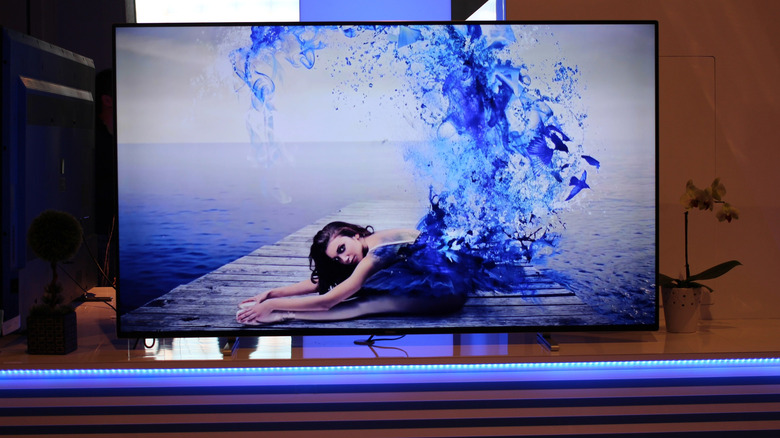 OLED TV on a home theater stand displaying a detailed image to show off color depth