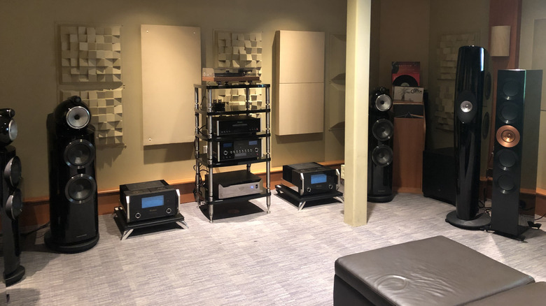 A variety of speakers and audio receivers on display in a sound-treated room