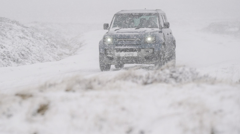 A car drives through the snowy landscape