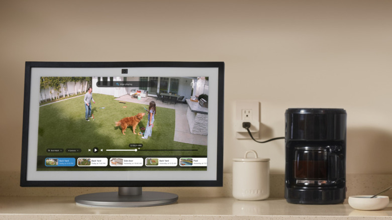 Man drinking coffee while watching family outside from Alexa screen and cameras