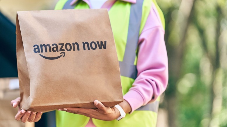 Amazon Now package being held by an Amazon delivery person