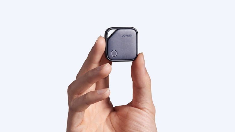 A hand holding the Ugreen FineTrack item tracker.