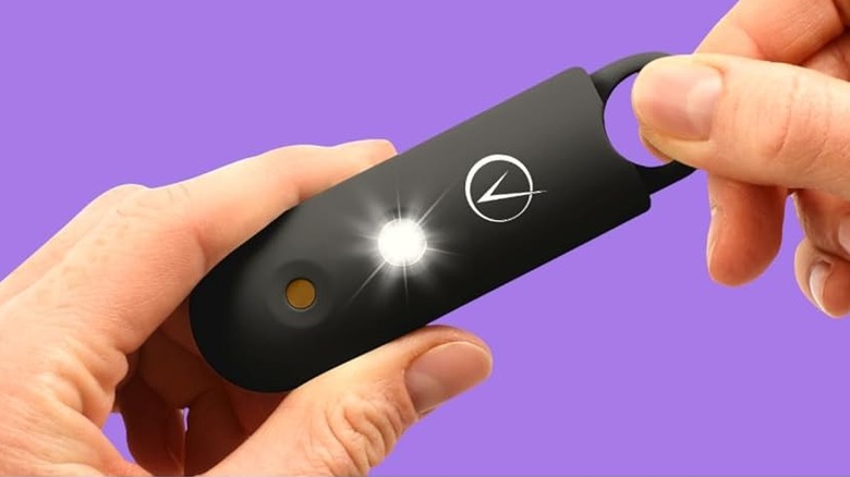 A person pulling the pin of the Vantamo personal alarm.