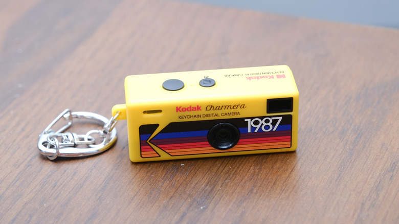 The Kodak Charmera digital camera, with its keychain, on a wooden desk.