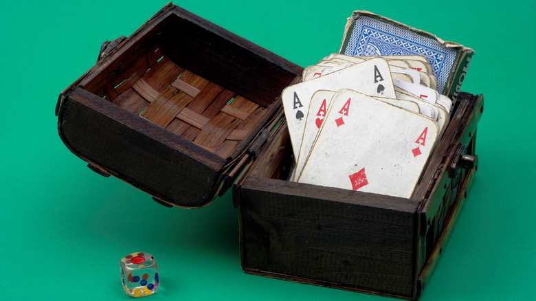 Old playing cards in a wooden box. 3D-printed deck boxes can be a stylish alternative.