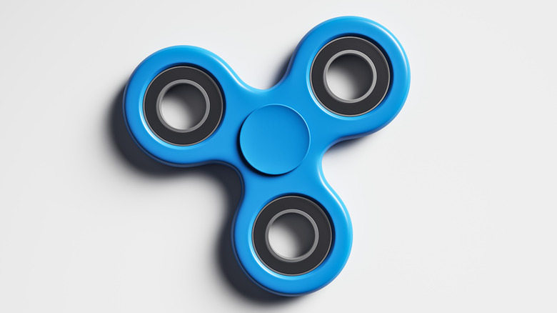 A blue fidget spinner against a light gray background.