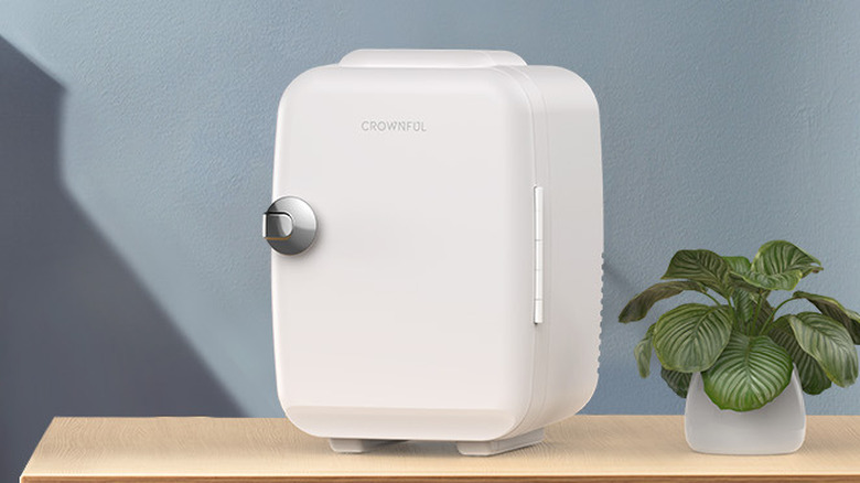 The Crownful 4L Mini Fridge in white, on a wooden desk.