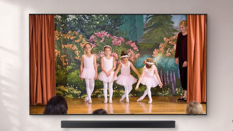 The Samsung U8000H Series 4K TV mounted on a wall with a soundbar.