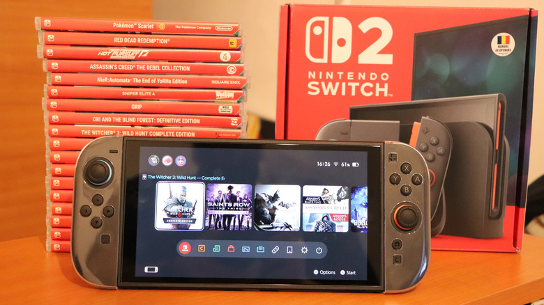 A Nintendo Switch 2 with its box and a stack of games at the back.