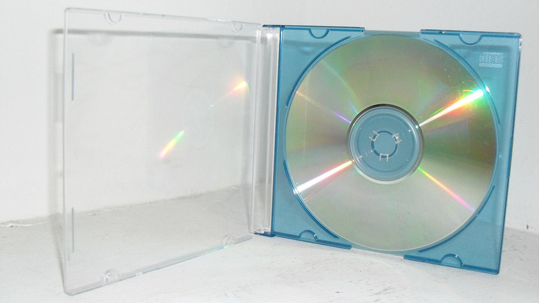 An unlabeled CD in a transparent blue case on a white surface.
