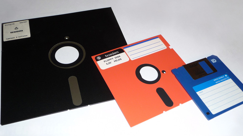 Three floppy disks in various colors and sizes against a white background.