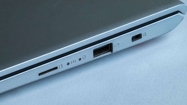 A headphone jack is visible among other ports on the side of a closed laptop.