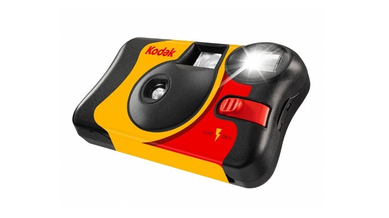 The Kodak FunSaver disposable camera with its flash activated, on a white background.