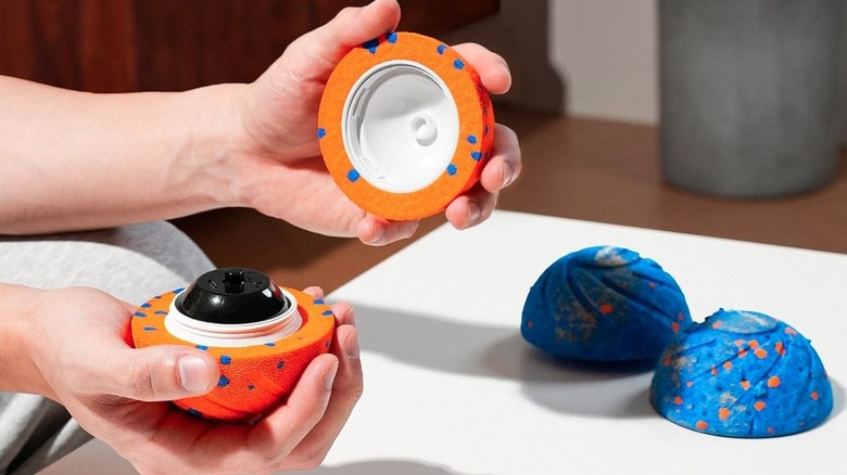 Hands holding the Cheerble Wicked Ball Air open to display the interior