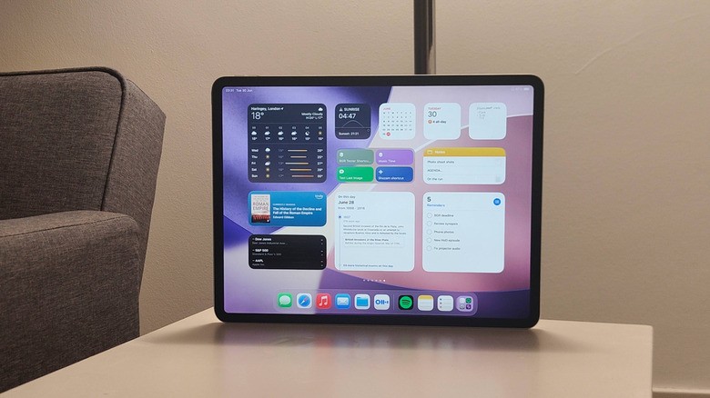 An iPad, with its home screen filled with various widgets.