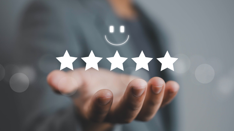 Holographic image of five stars and happy face emoji.