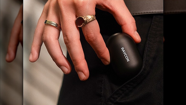 Woman placing Raycon earbuds in her pocket.