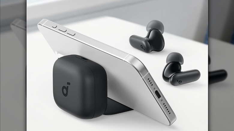 Smartphone placed against an earbud stand.