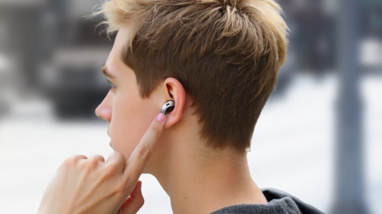Man touching an earbud.