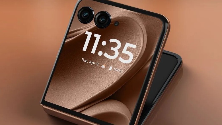 A half-folded Motorola Razr+ on a brown background