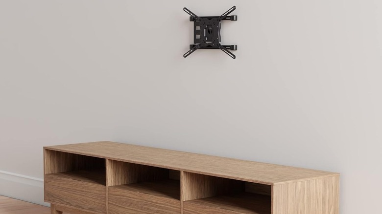 An articulated TV wall mount above a low cabinet.